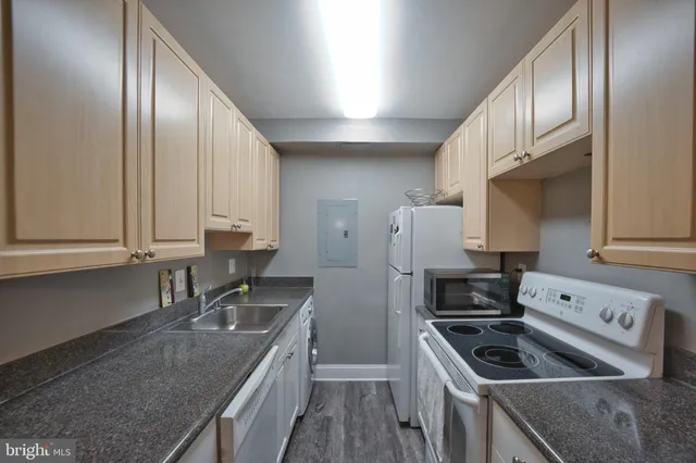 a kitchen with granite countertop stainless steel appliances a sink a stove and a refrigerator