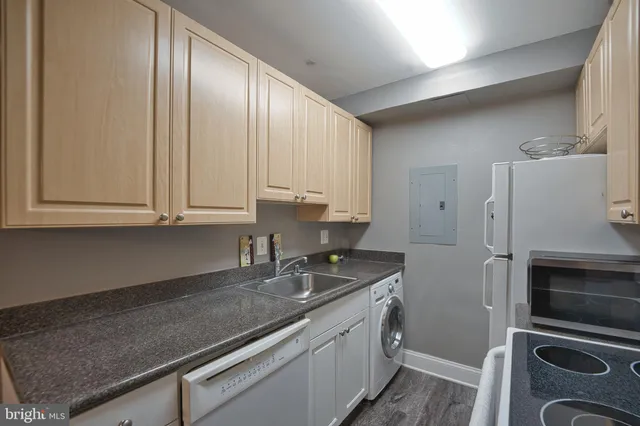a kitchen with granite countertop a refrigerator stove and sink