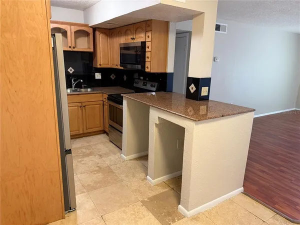 a kitchen with a sink a stove and a microwave