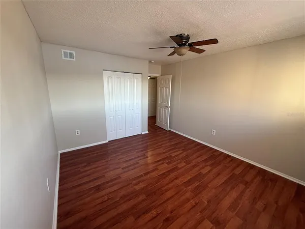 a view of empty room with wooden floor