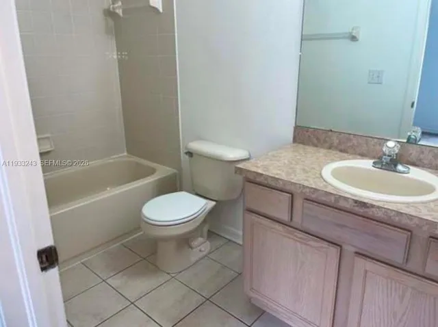 a bathroom with a granite countertop toilet a sink and bathtub