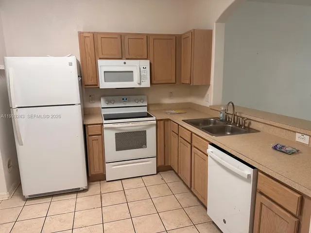 a kitchen with a sink a stove a refrigerator and cabinets