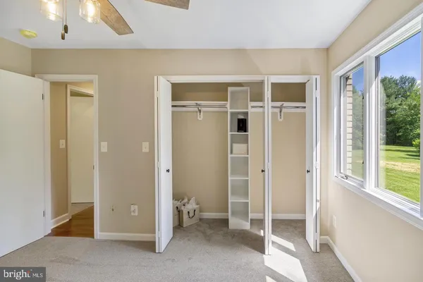 an empty room with a window and a ceiling fan