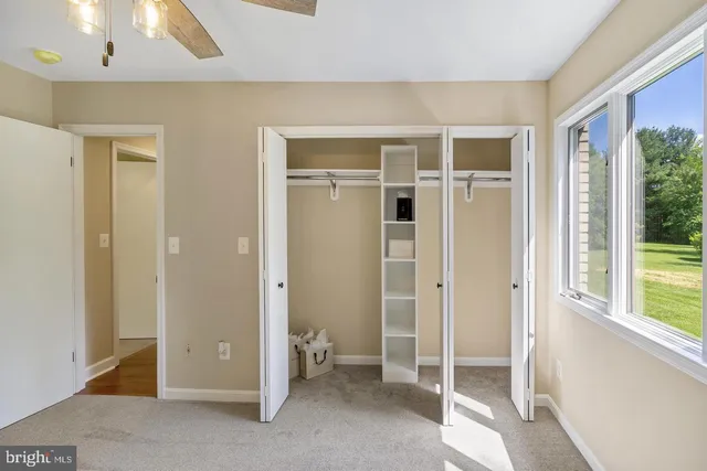 an empty room with a window and a ceiling fan