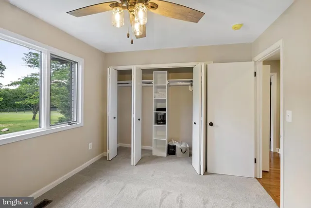 an empty room with a window and a fan