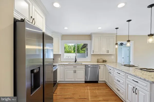 a large kitchen with a sink stainless steel appliances and cabinets