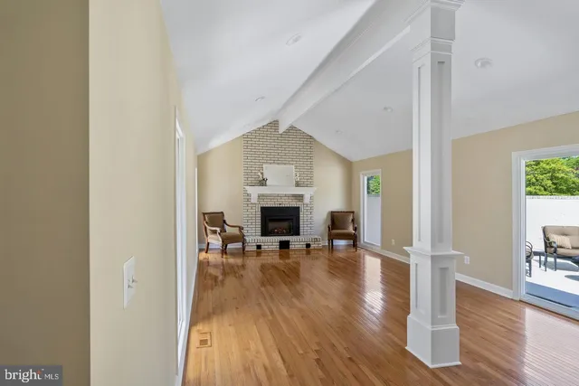 a view of a livingroom with wooden floor and a fireplace