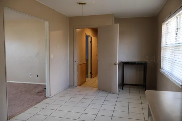 an empty room with closet and windows