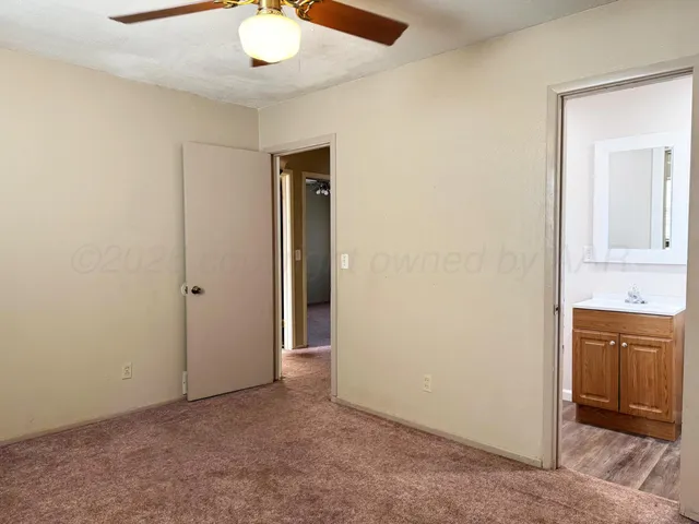 an empty room with chandelier fan