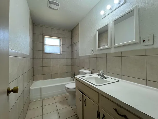 a bathroom with a sink a bathtub and next to a window