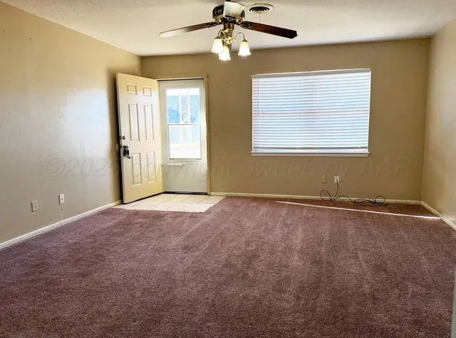 en empty room with windows and ceiling fan
