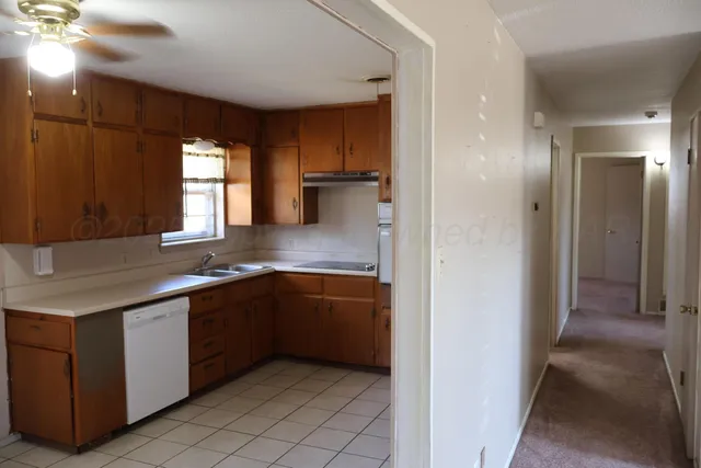 a kitchen with stainless steel appliances granite countertop a sink and a refrigerator