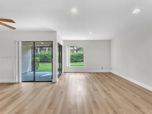 an empty room with wooden floor and sliding door