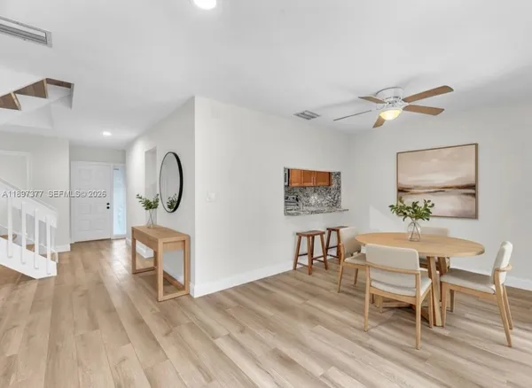 a view of an empty room with window wooden floor and a chandelier fan