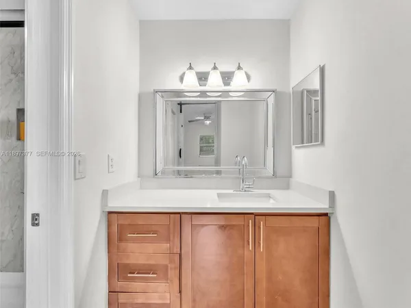 a view of an empty room with wooden floor and windows