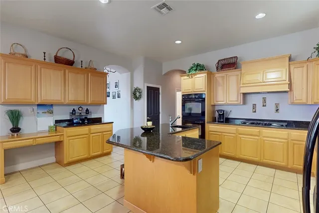a kitchen with stainless steel appliances granite countertop a sink a stove and cabinets