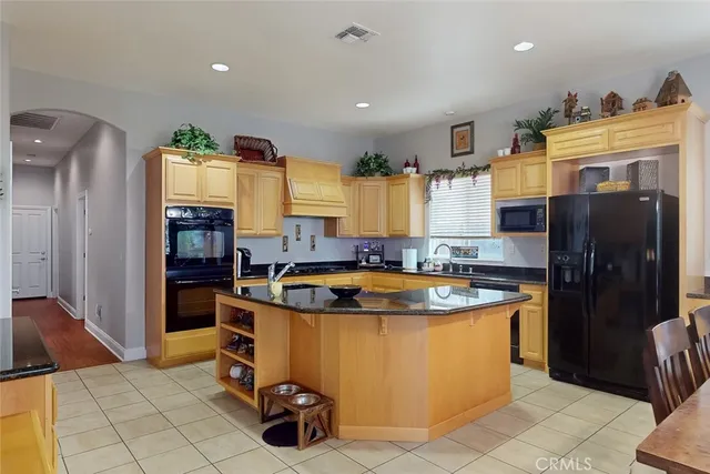 a kitchen with stainless steel appliances granite countertop a sink and a refrigerator