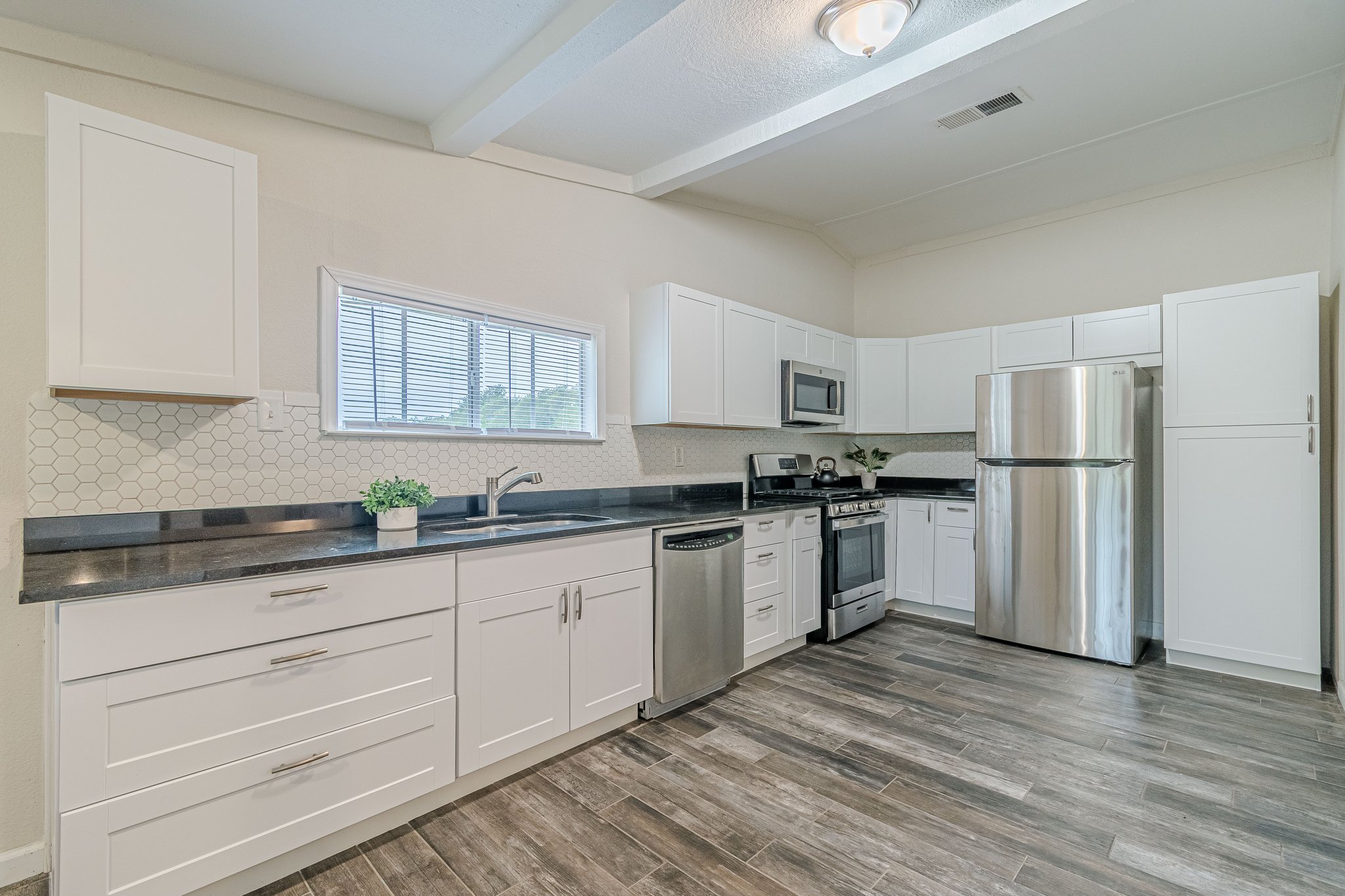 560 Persimmon Pass Fischer, TX 78623 - Photo 9 of 26 a kitchen with granite countertop white cabinets and white appliances
