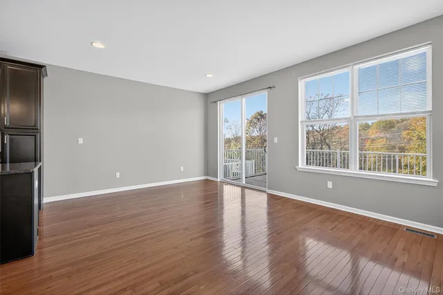 a kitchen with stainless steel appliances kitchen island granite countertop a refrigerator a stove and a wooden floors