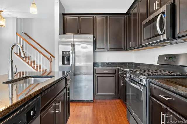 a kitchen with stainless steel appliances granite countertop a refrigerator stove and oven