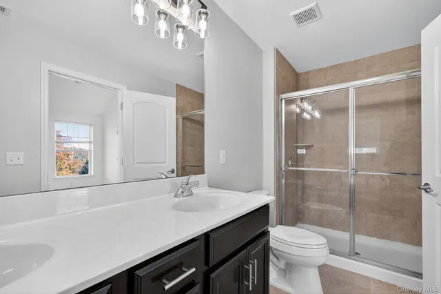 a bathroom with a sink double vanity granite tub and a mirror