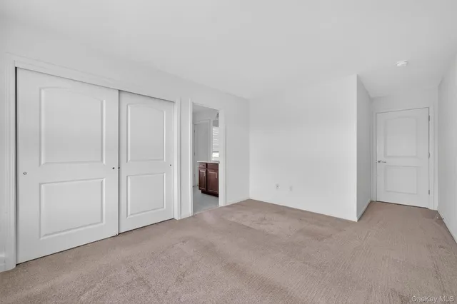 a view of an empty room with window and closet
