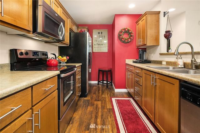a kitchen with stainless steel appliances granite countertop a stove a sink and a microwave