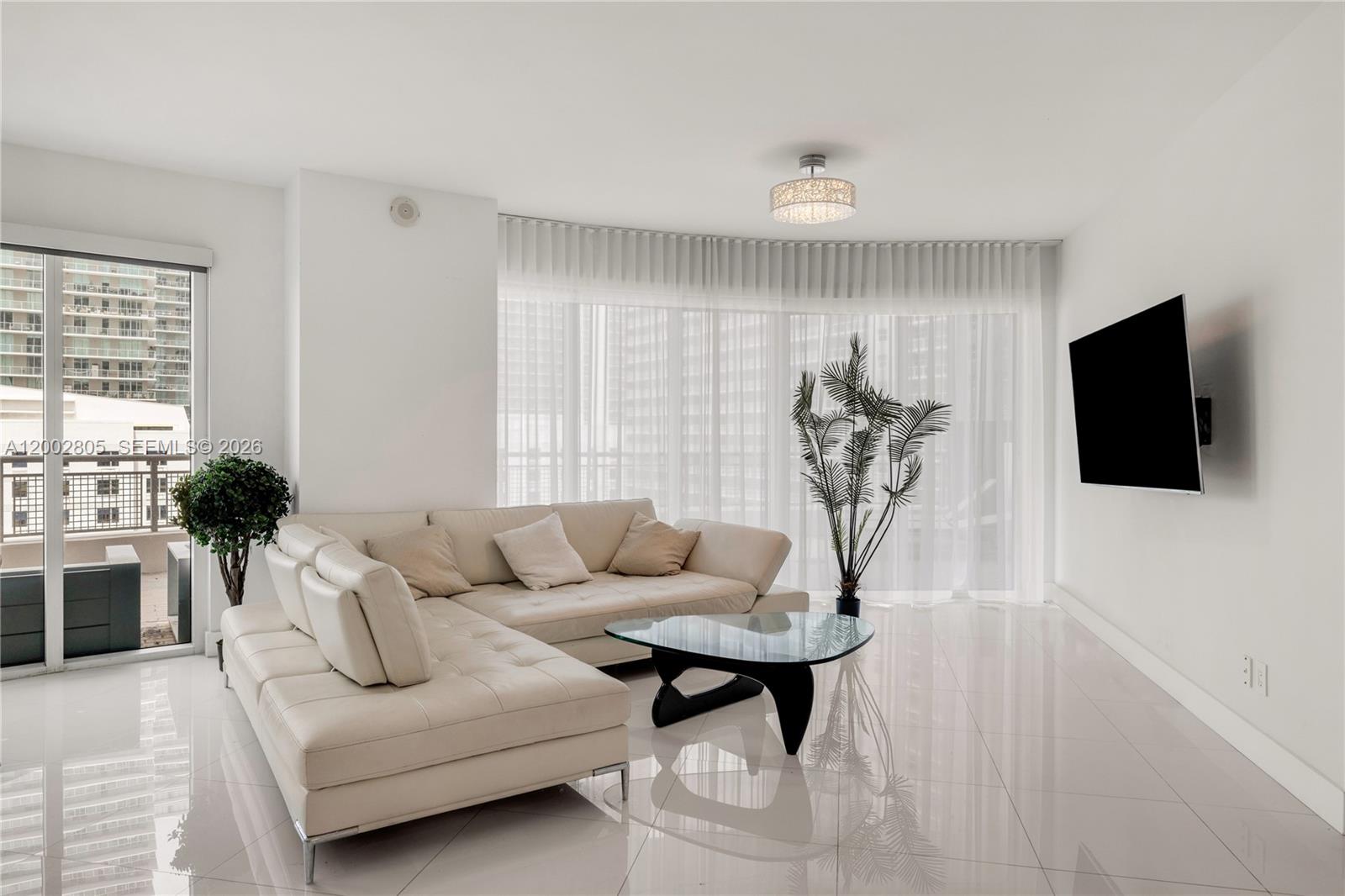 60 Southwest 13th Street, Unit 1124 Miami, FL 33130 - Photo 2 of 30 a living room with furniture and a flat screen tv