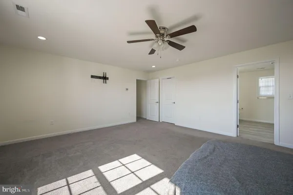 a view of a big room with wooden floor and windows