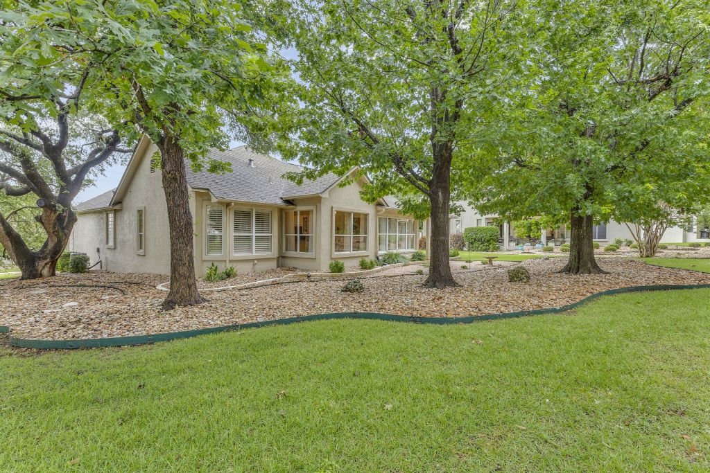 144 Cattle Trail Way Georgetown, TX 78633 - Photo 27 of 37 Mature trees and lush greenery frame this inviting home, offering abundant curb appeal.