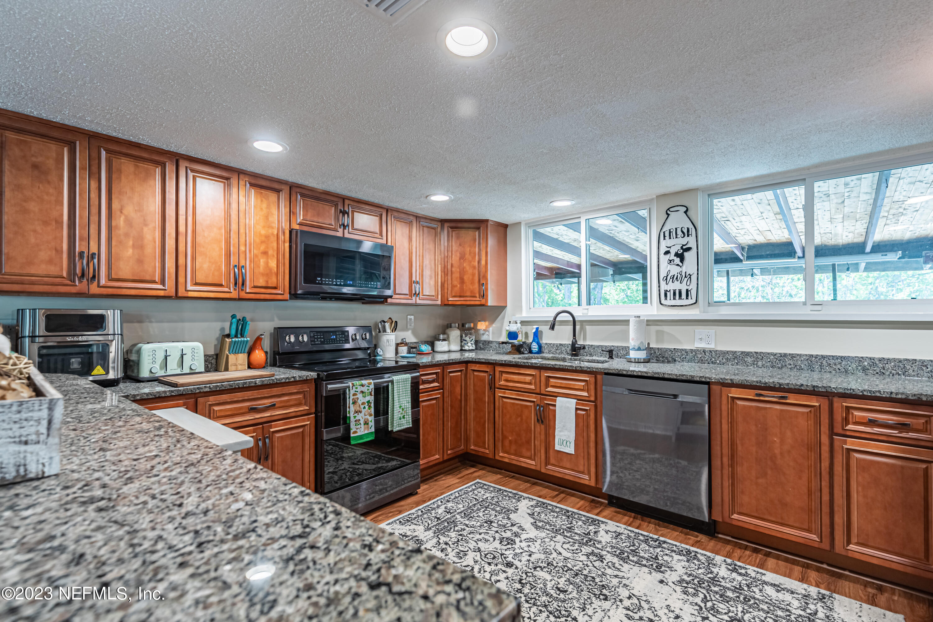 2036 Cornell Road Middleburg, FL 32068 - Photo 21 of 62 a kitchen with stainless steel appliances granite countertop a stove a sink dishwasher a refrigerator and a microwave oven