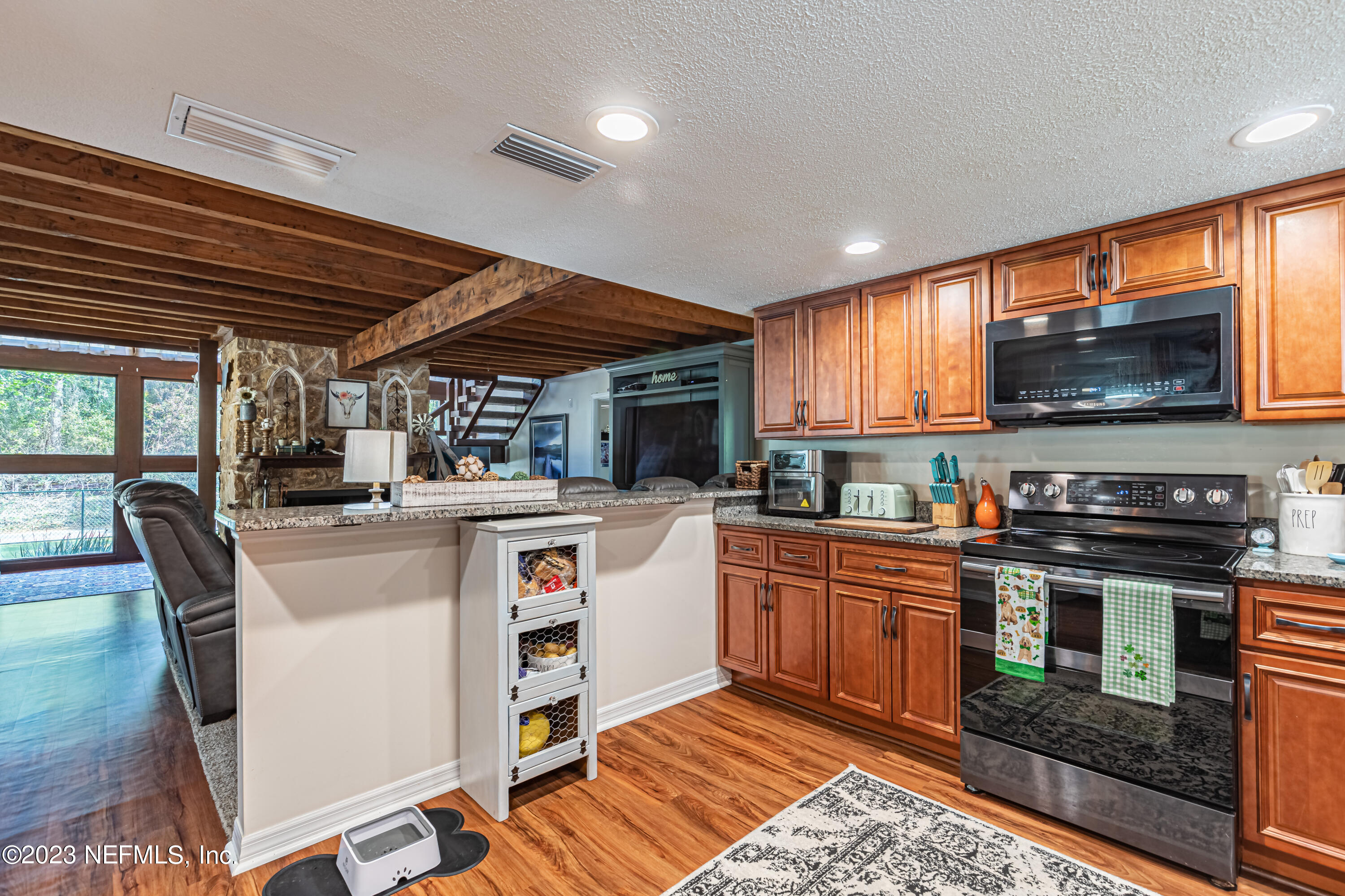 2036 Cornell Road Middleburg, FL 32068 - Photo 22 of 62 a kitchen with stainless steel appliances granite countertop a stove top oven a sink dishwasher a dining table and chairs with wooden floor