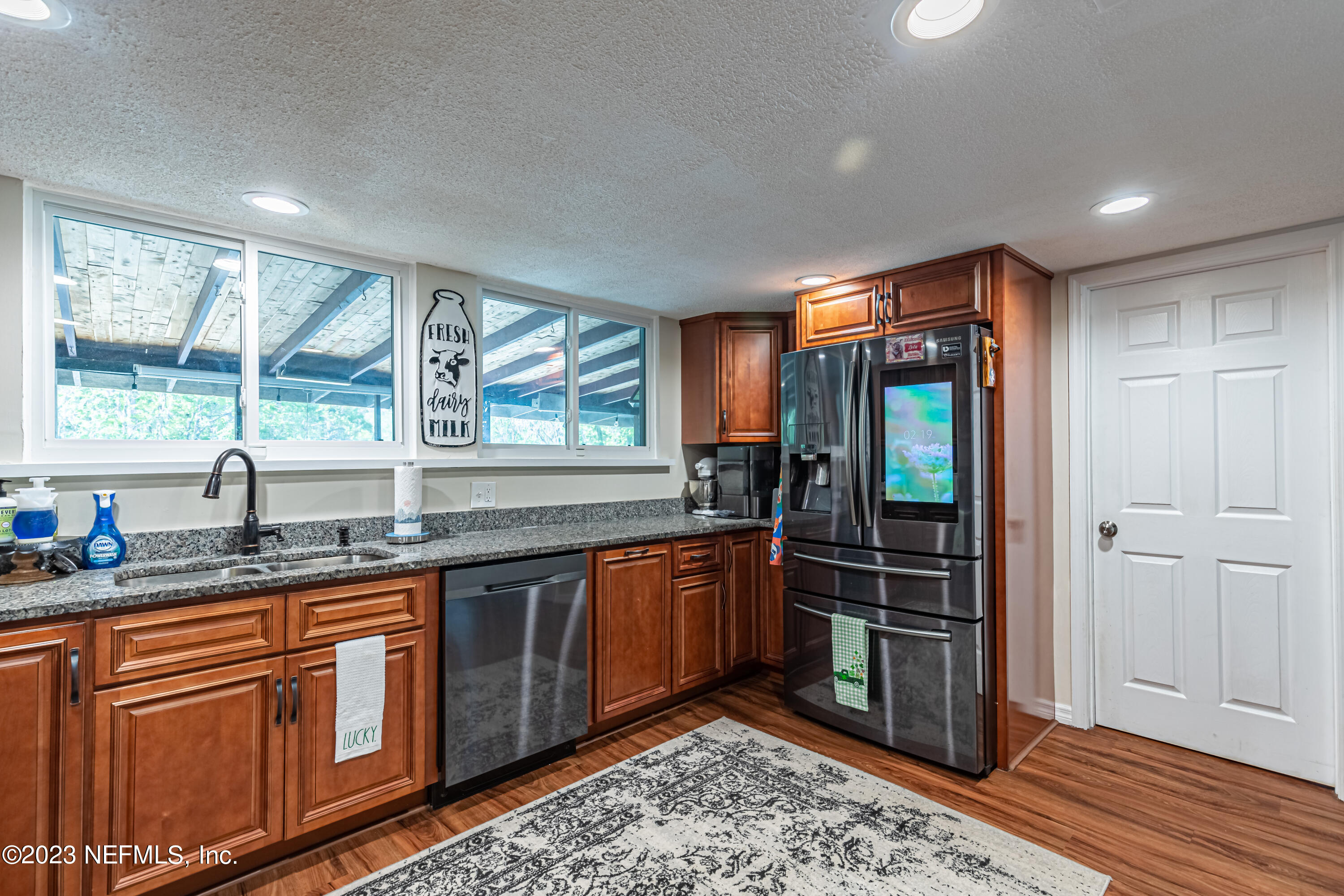 2036 Cornell Road Middleburg, FL 32068 - Photo 23 of 62 a kitchen with stainless steel appliances granite countertop a sink and wooden cabinets