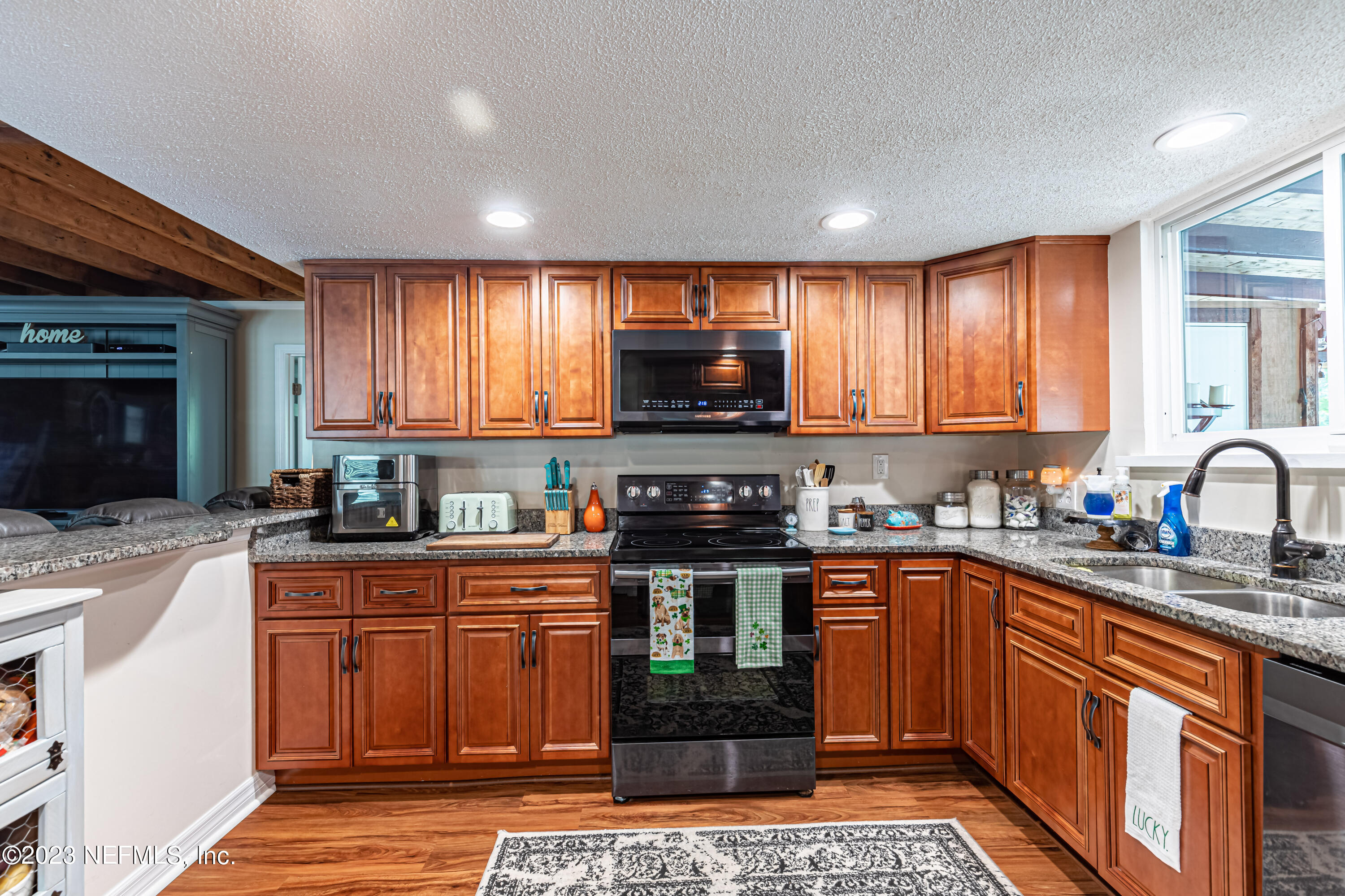 2036 Cornell Road Middleburg, FL 32068 - Photo 24 of 62 a kitchen with stainless steel appliances granite countertop wooden cabinets a stove top oven a sink and dishwasher