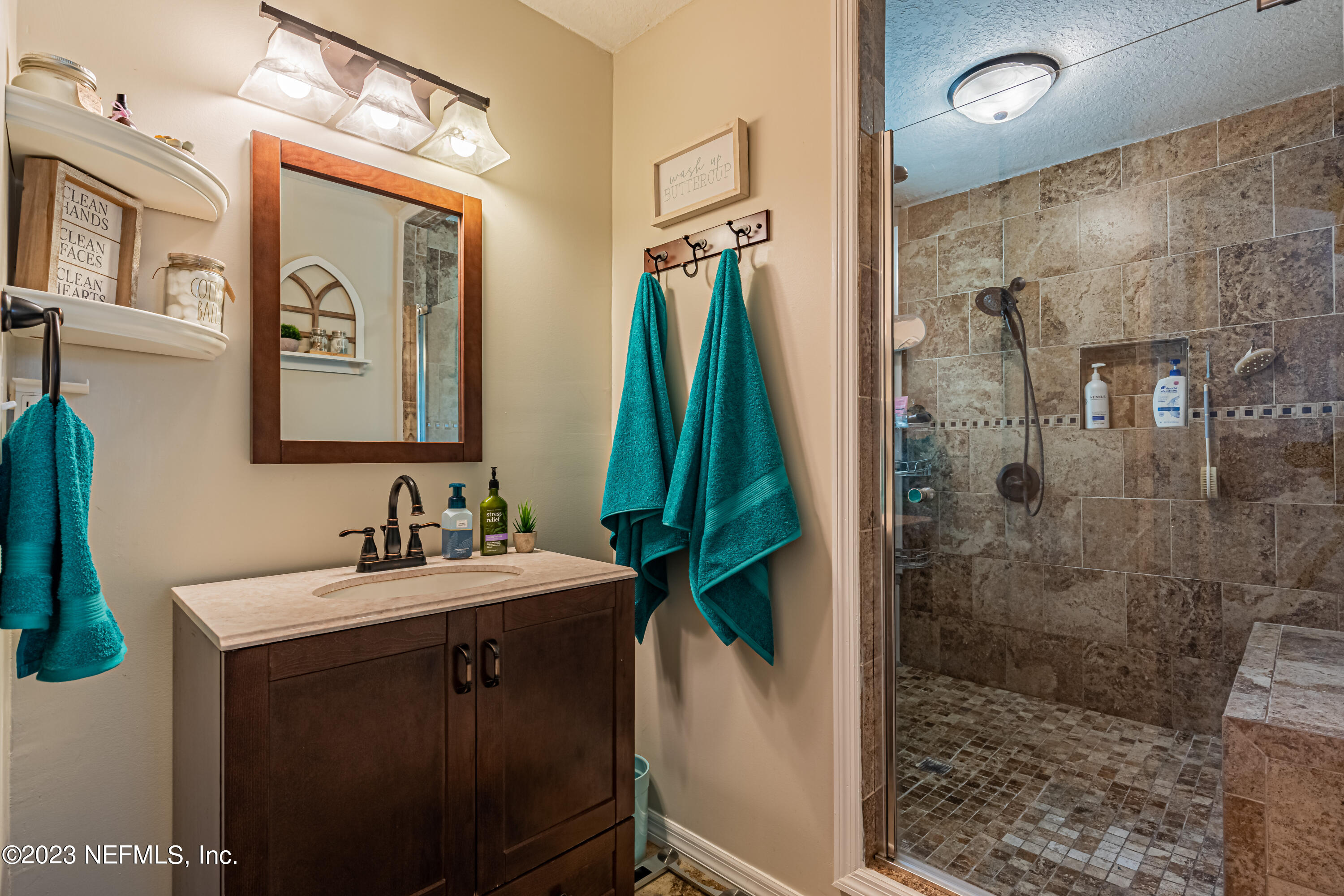 2036 Cornell Road Middleburg, FL 32068 - Photo 30 of 62 a bathroom with a sink a mirror and a shower
