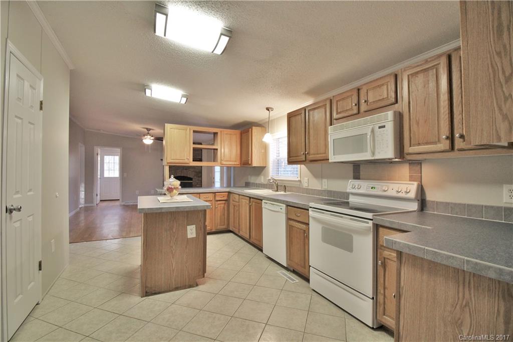 734 Farley Road Fort Mill, SC 29715 - Photo 8 of 23 a kitchen with stainless steel appliances granite countertop a stove top oven a sink dishwasher and white cabinets with wooden floor