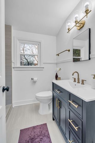a spacious bathroom with a toilet a sink and mirror