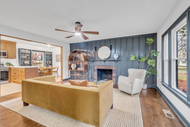 a living room with furniture a fireplace and a large window