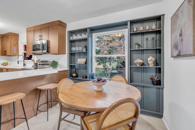 a dining room with furniture a window and kitchen view
