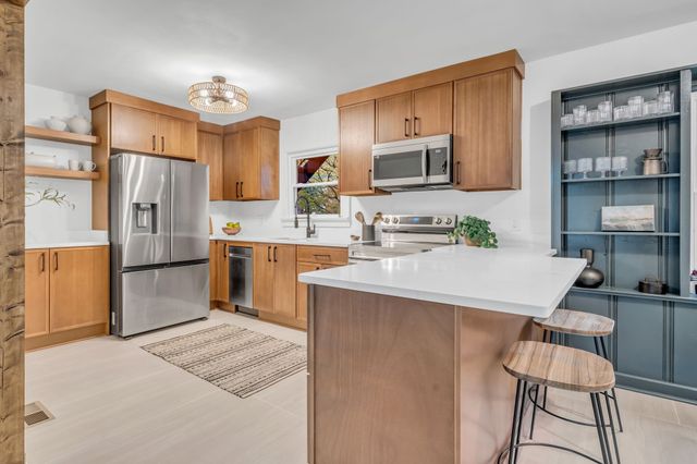 a kitchen with stainless steel appliances a refrigerator stove microwave and sink