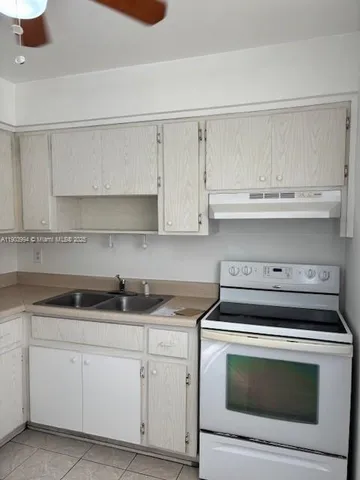a kitchen with white cabinets and appliances