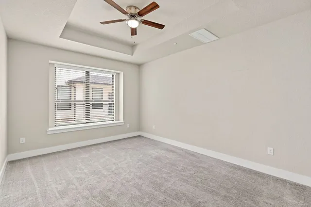 an empty room with a window and a fan