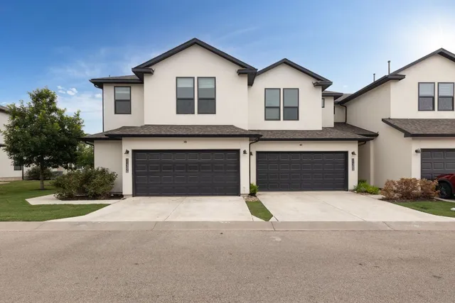 a front view of a house with yard and garage