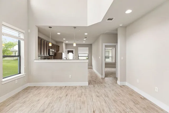 a view of a kitchen with wooden floor and a window