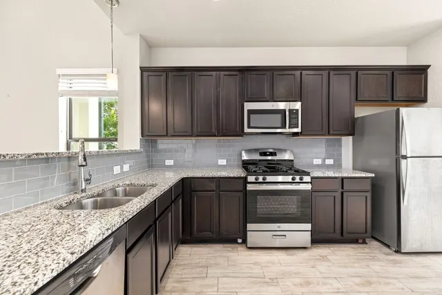 a kitchen with a sink stove and refrigerator