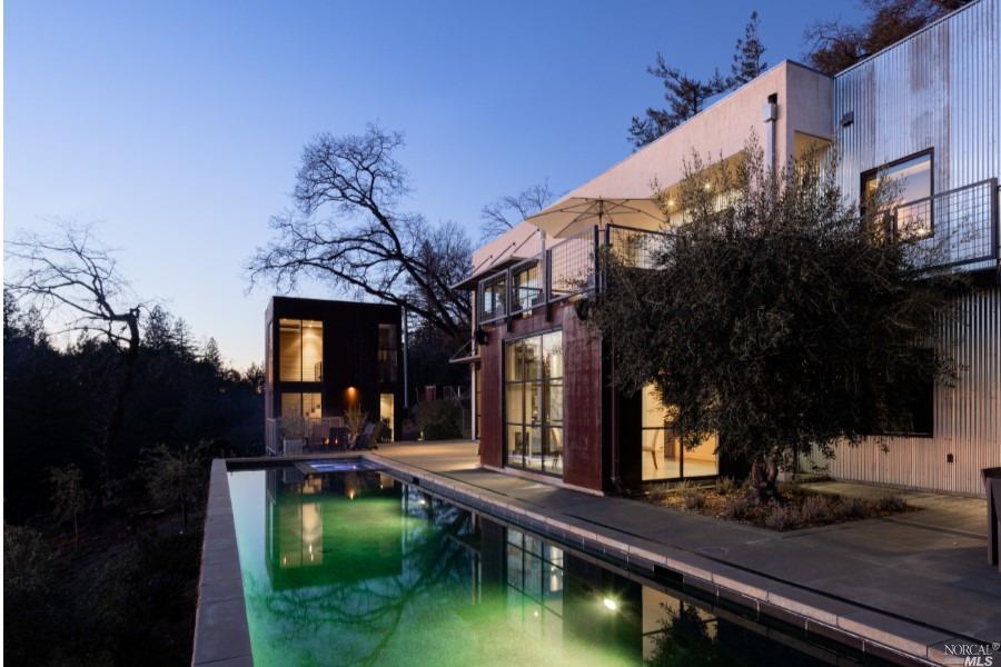 a view of a house with pool and sitting area