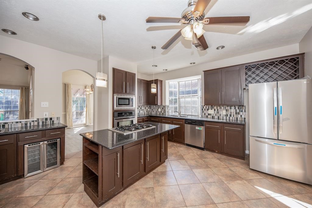 11527 Earley Forest Lane Houston, TX 77043 - Photo 11 of 32 Spacious open-concept kitchen featuring a wet bar and stylish backsplash