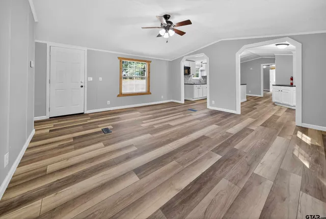 a view of empty room with window and ceiling fan
