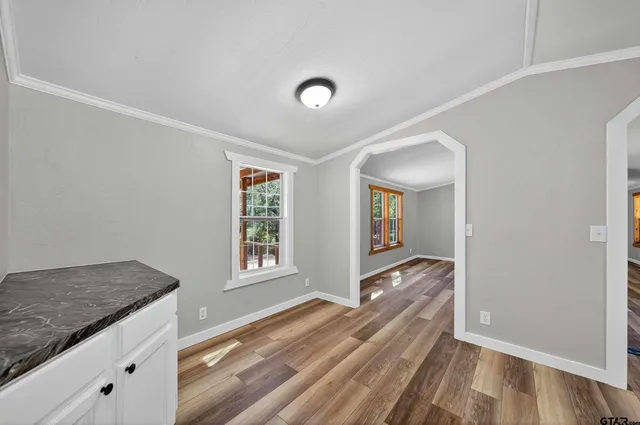 a view of hallway with wooden floor and cabinet
