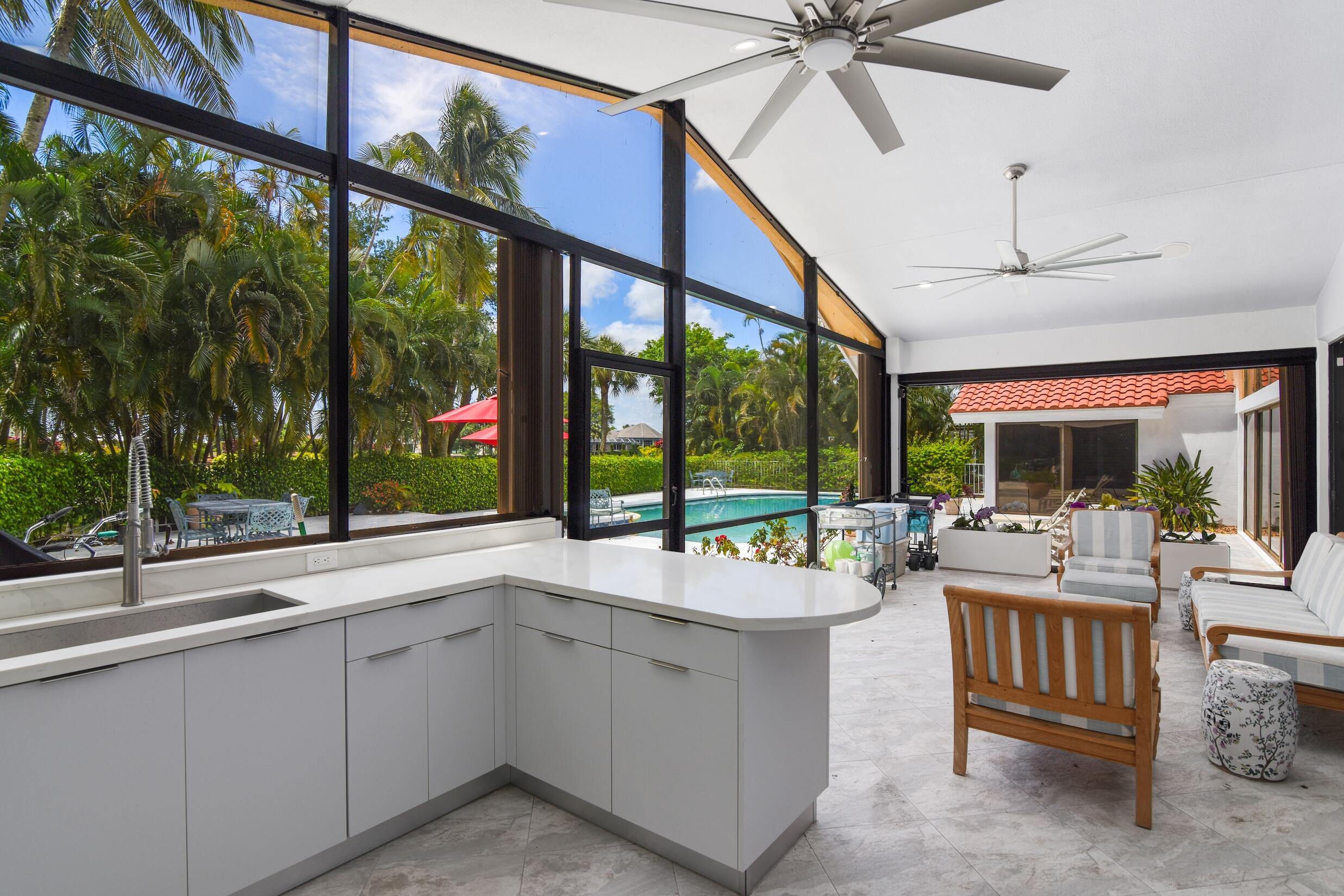 4335 Bocaire Boulevard Boca Raton, FL 33487 - Photo 20 of 55 a room with lots of tables a large window and a couch